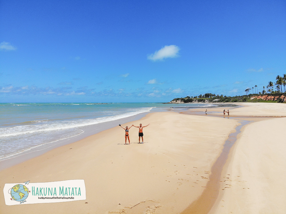 Dos personas en la playa junto al mar. Praia do Imbassuaba - 10 playas para conocer en Bahía