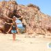 Dos personas en la playa bajo un arco de piedras, en Pedra Furada