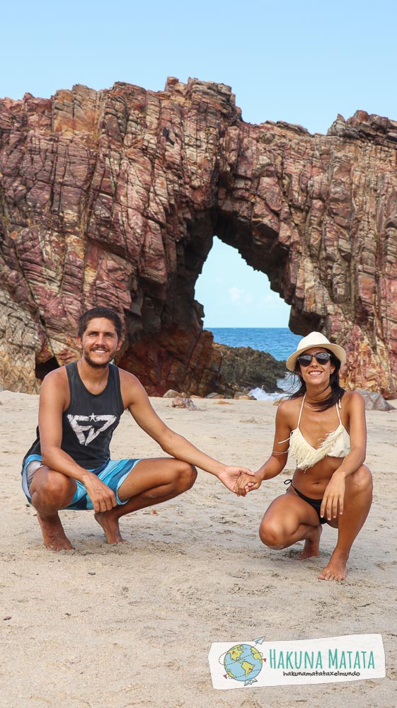 Que hacer en Jericoacoara: dos personas de la mano en Pedra Furada, un arco de piedras
